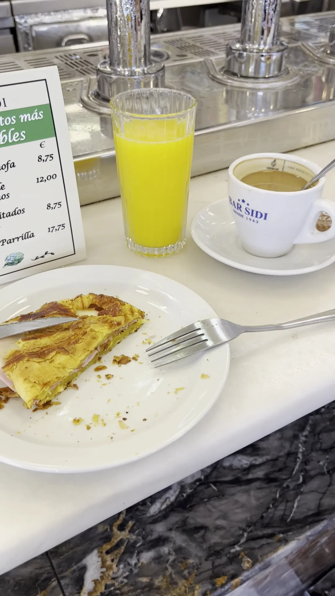 A slice of Spanish tortilla on a plate with silverware