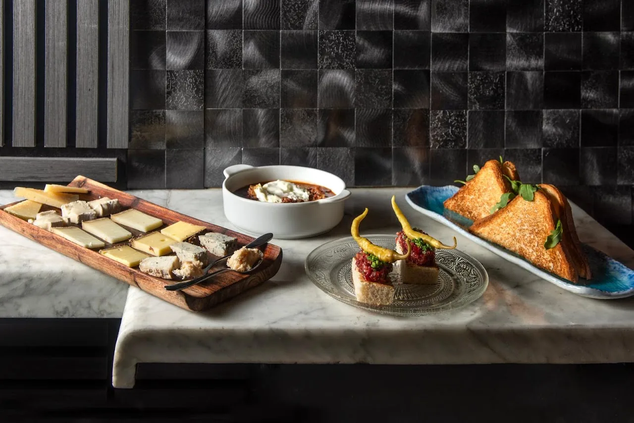 A spread of small plates and toasts arranged on a marble board