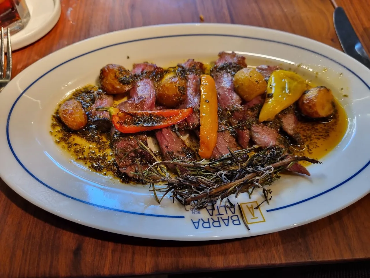 A platter of grilled meat with charred vegetables and lemon