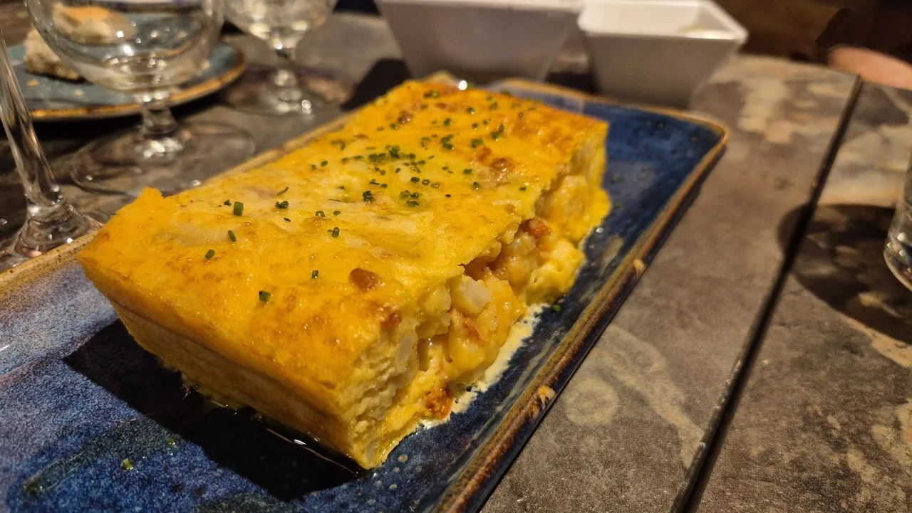 A golden baked slice with herbs on a long blue dish