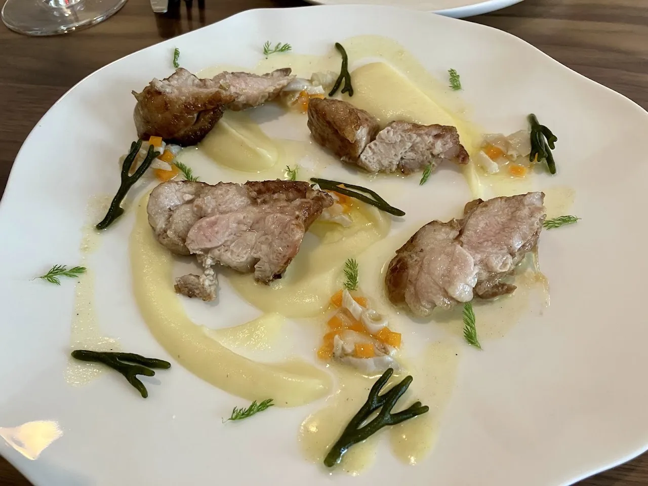 Sliced pork medallions with a cream sauce, green beans, and diced vegetables