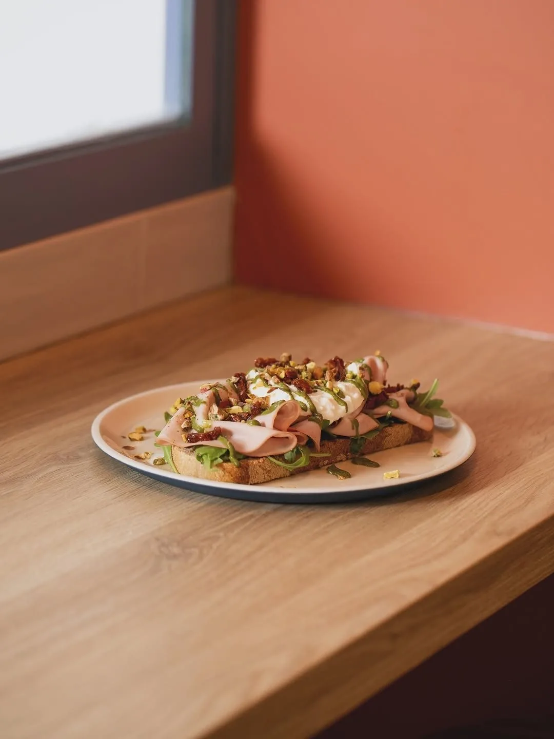 A plate of open toasts with toppings on a wooden counter