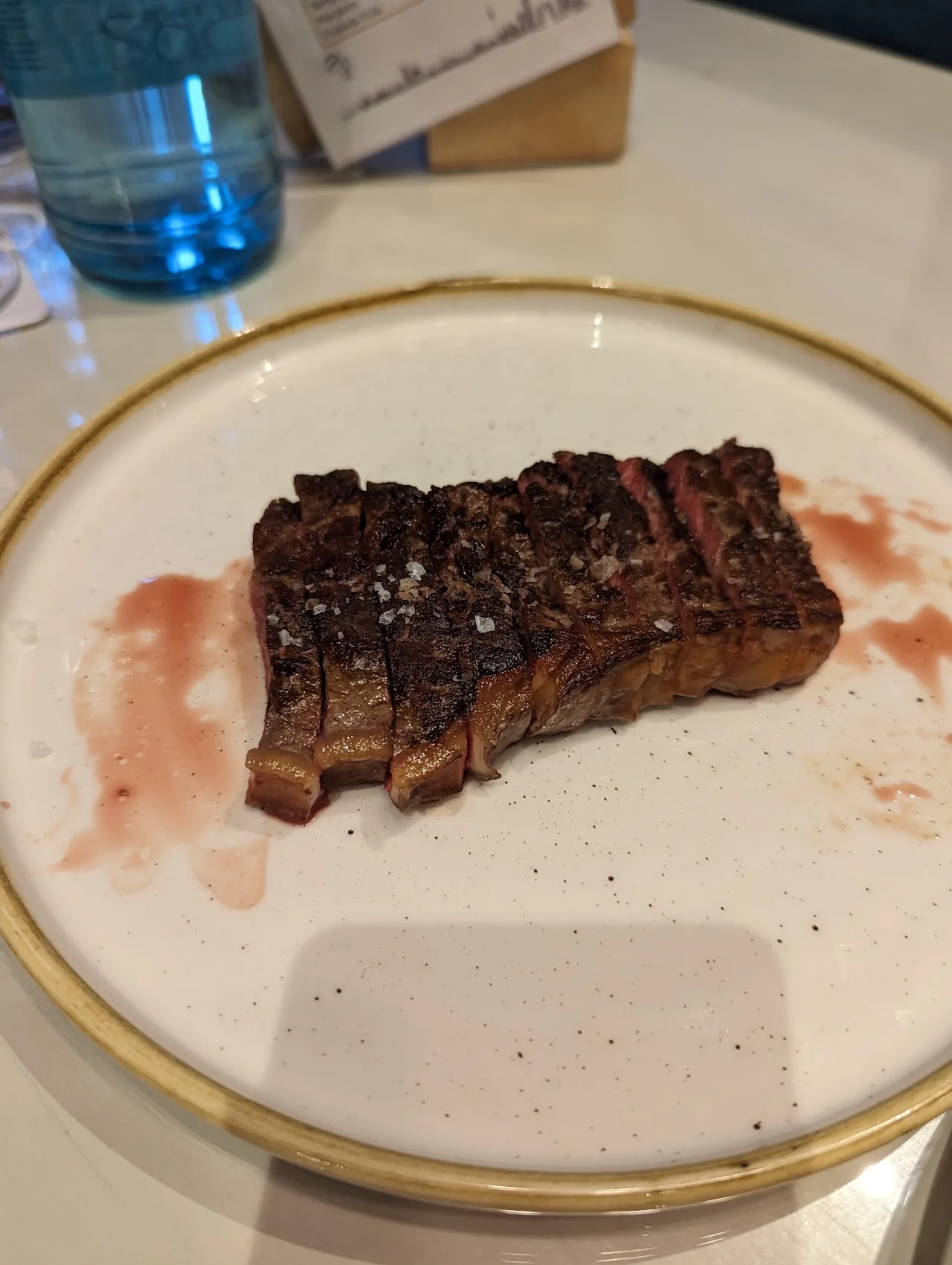 Sliced grilled meat with a dark sauce on a plate