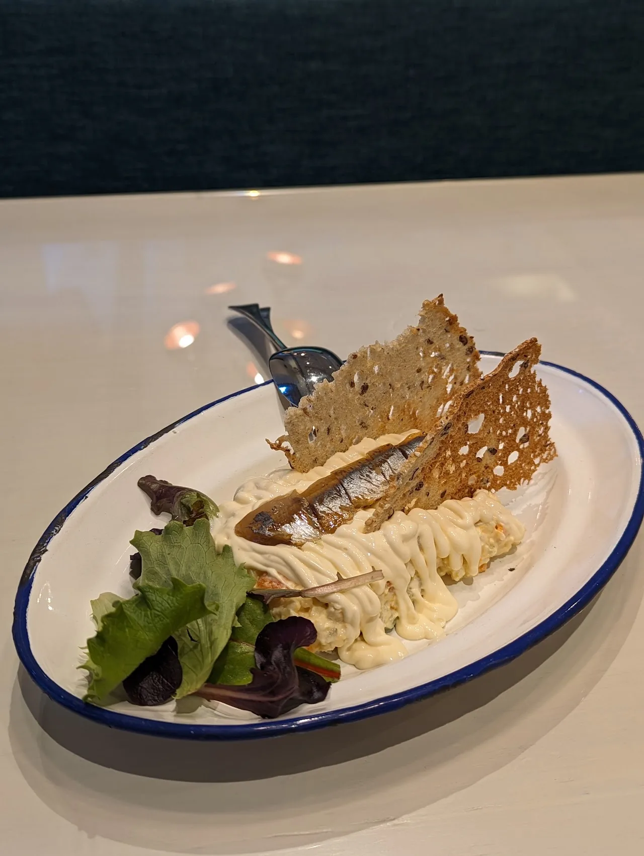 A crispy tuile with salad greens and a creamy dip