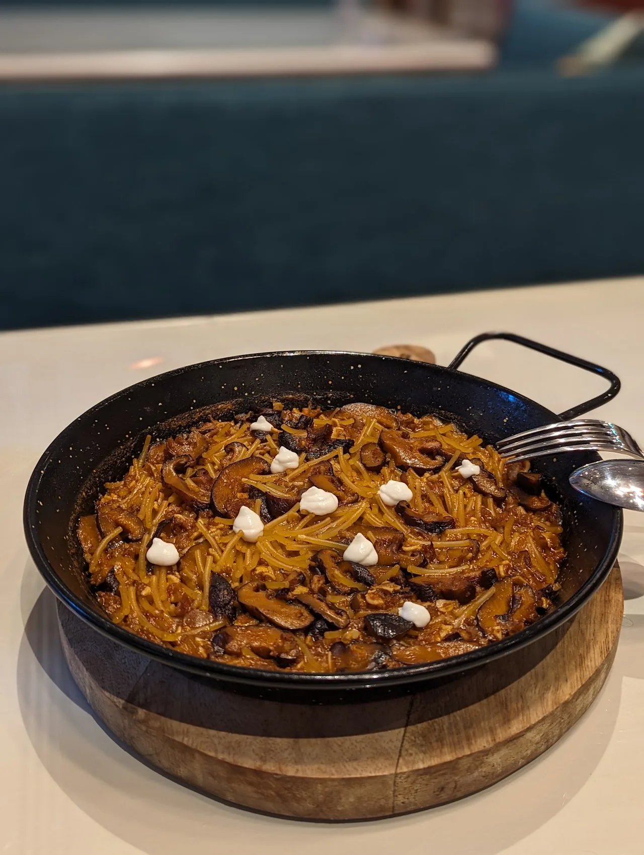A pot of noodles in tomato sauce with dollops of cream
