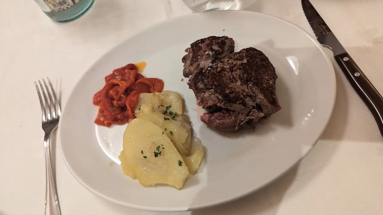 A plate of meat with mashed potato and a red pepper relish