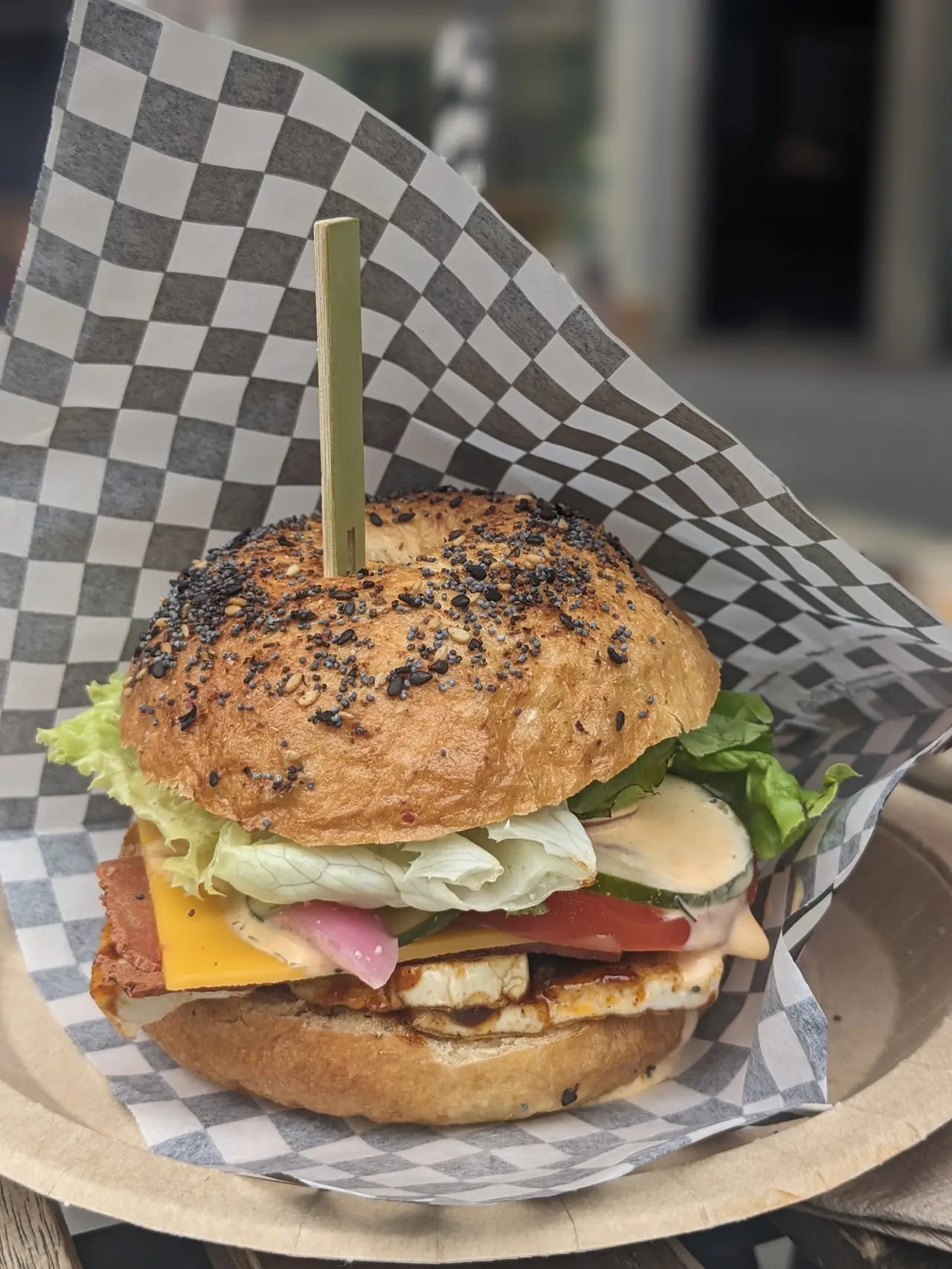 Everything bagel sandwich with grilled halloumi, cheddar, lettuce, tomato and pickled onion