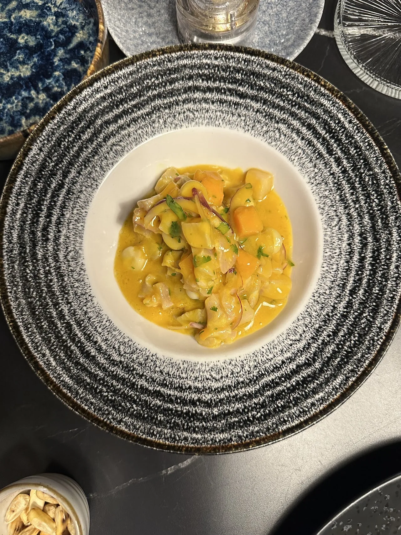A bowl of yellow stew or soup with vegetables