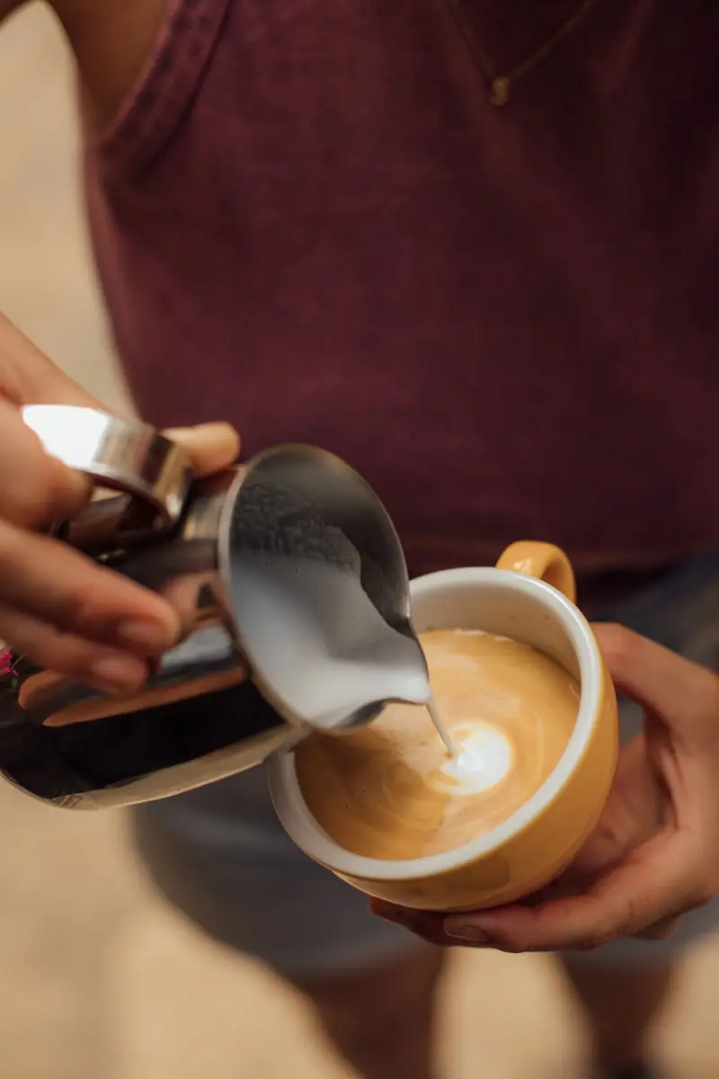 A barista pouring latte art at Bo's