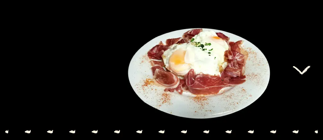 Fried eggs with Iberian ham and paprika on a white plate at Bodega Pàdua