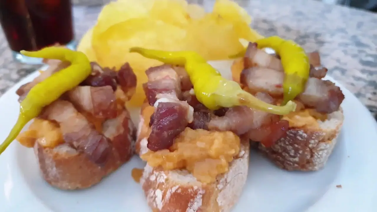 Toasted bread topped with bacon and pickled yellow peppers.