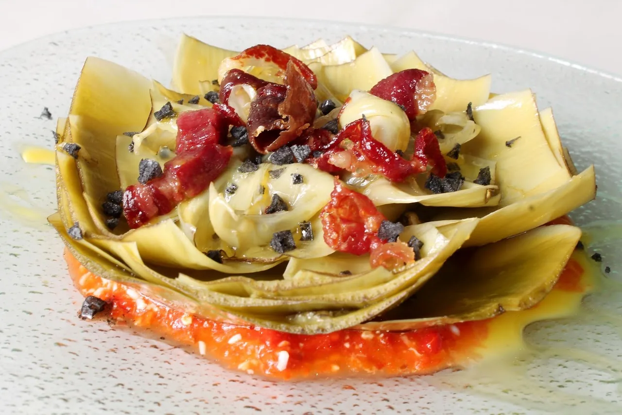 A plate of pasta with ham strips, cheese, and tomato sauce