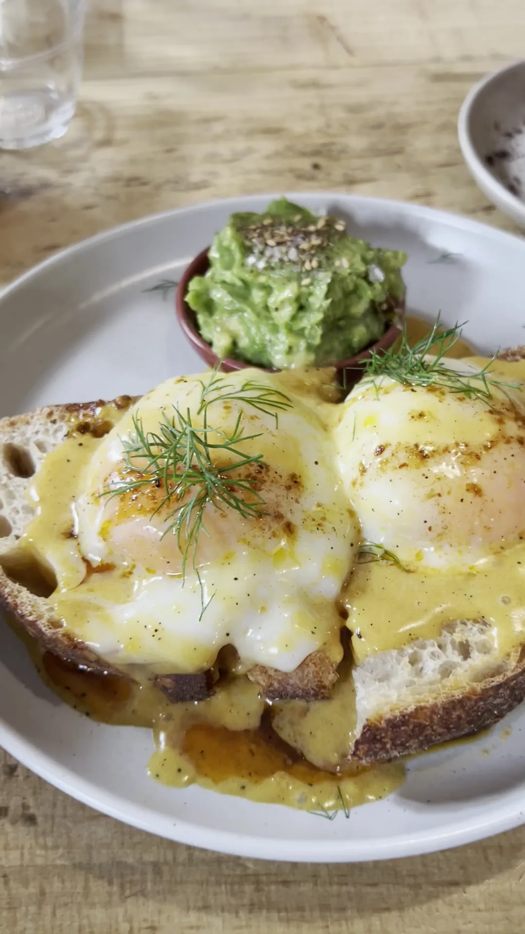 Eggs benedict on toast with avocado