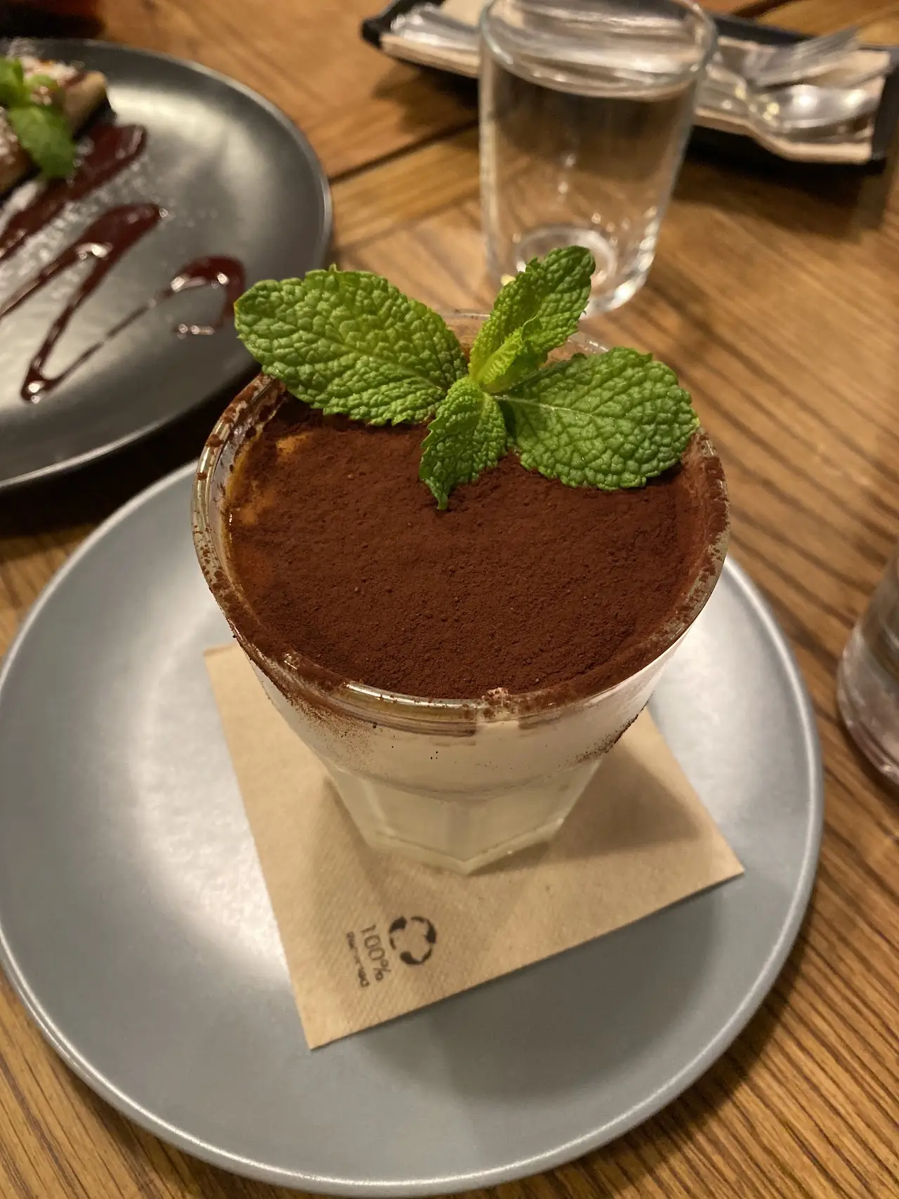 Tiramisu topped with cocoa powder and a mint sprig.