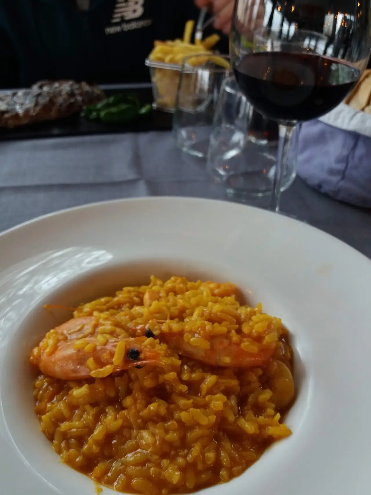 A plate of yellow rice with whole shrimp