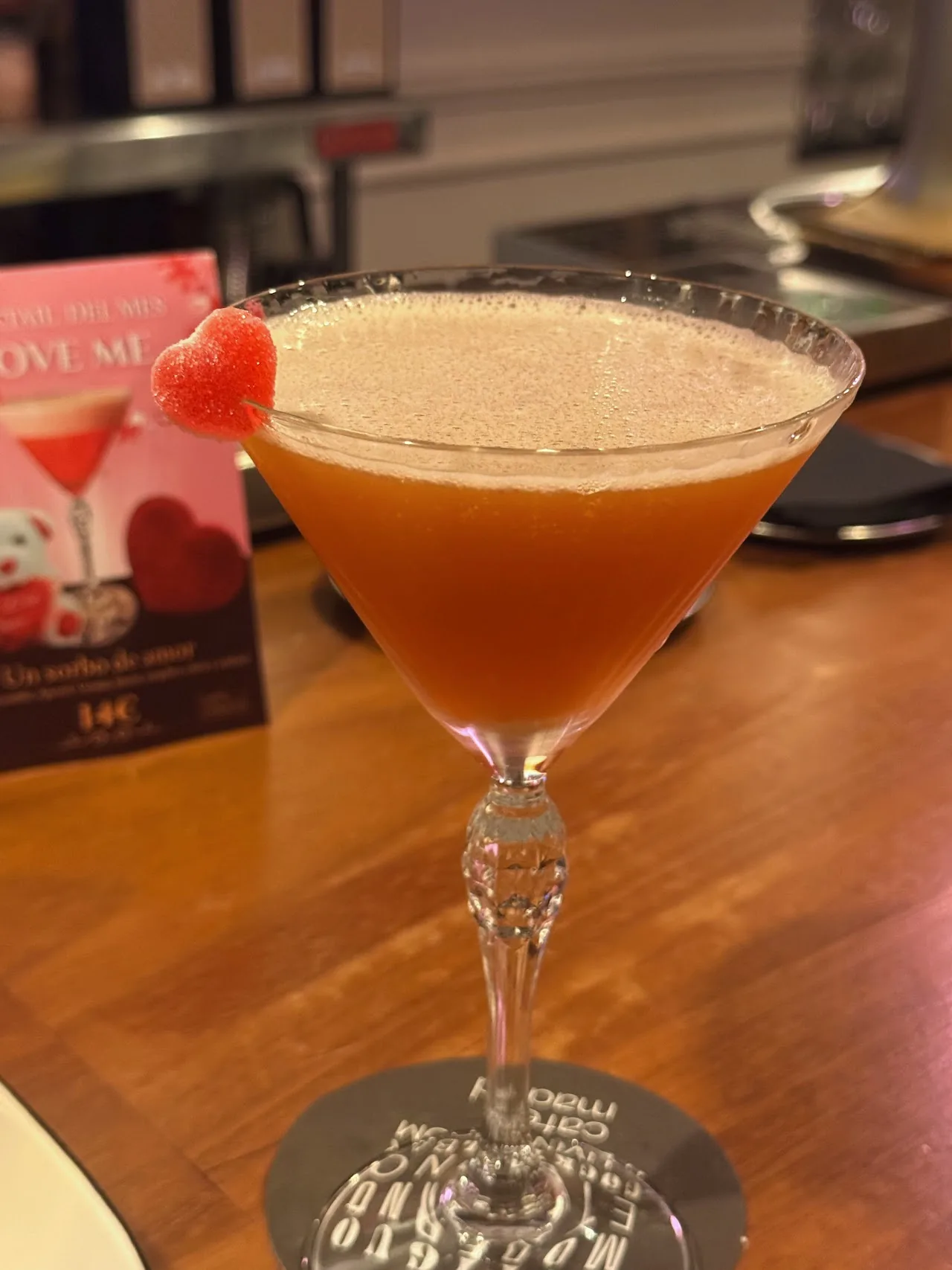 An orange-colored cocktail in a martini glass
