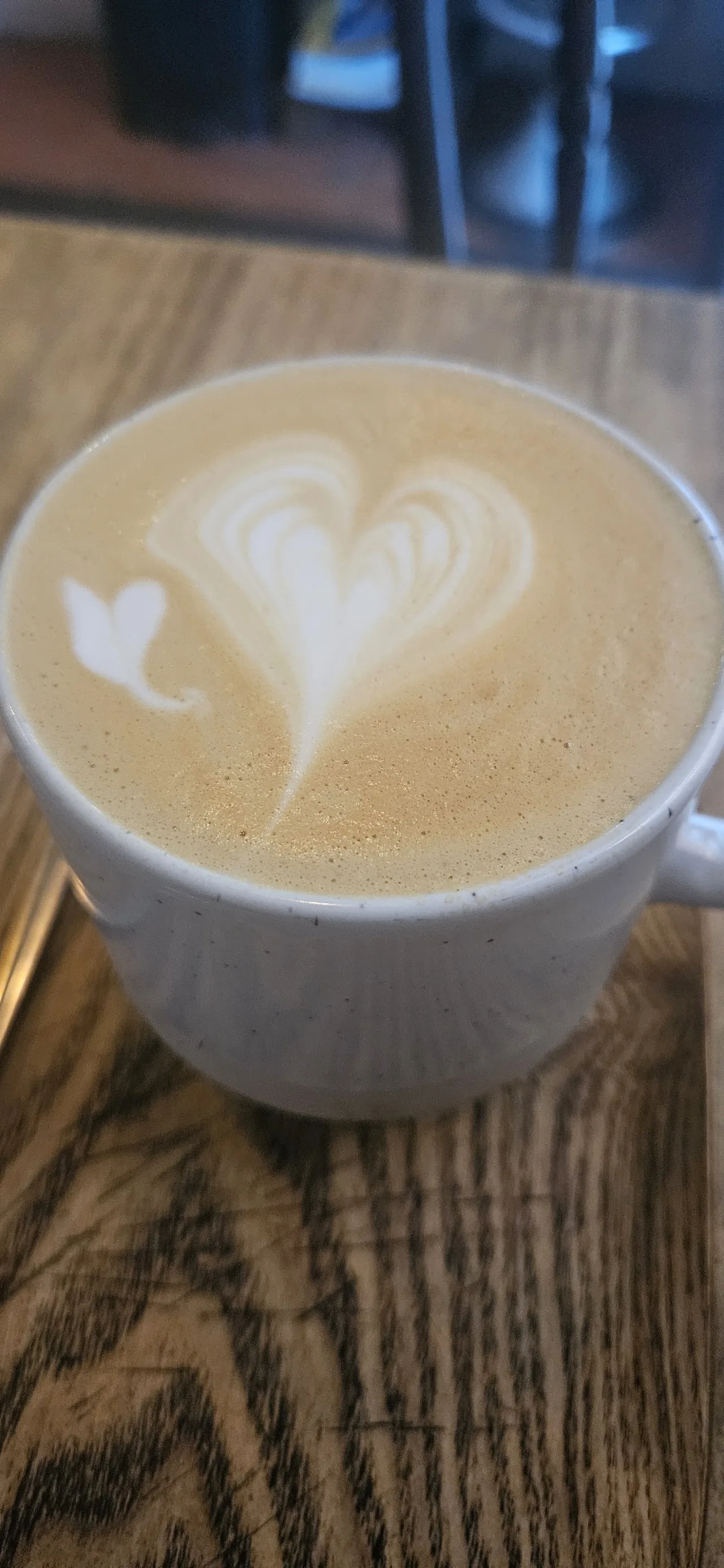 A cappuccino with heart-shaped latte art in a white cup