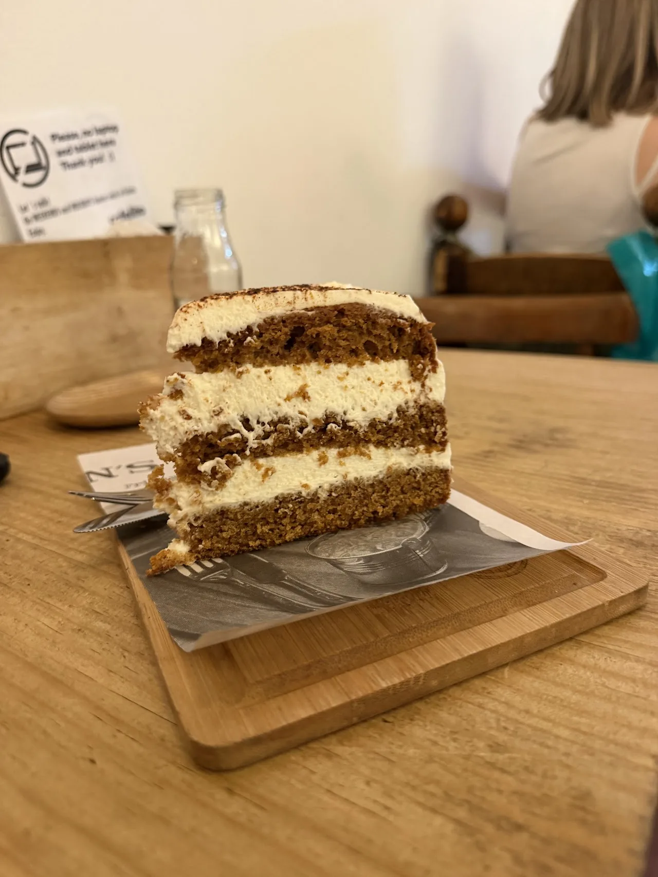 A slice of layered cake on a wooden board