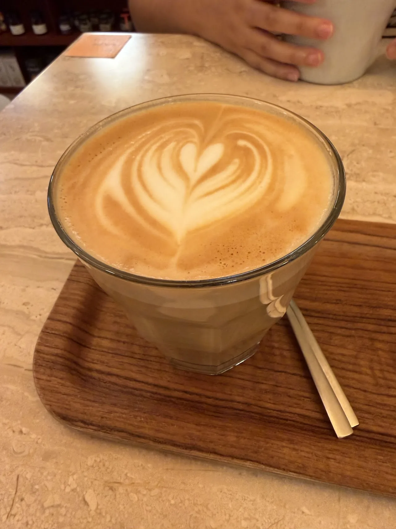 A latte in a glass cup with heart-shaped foam art
