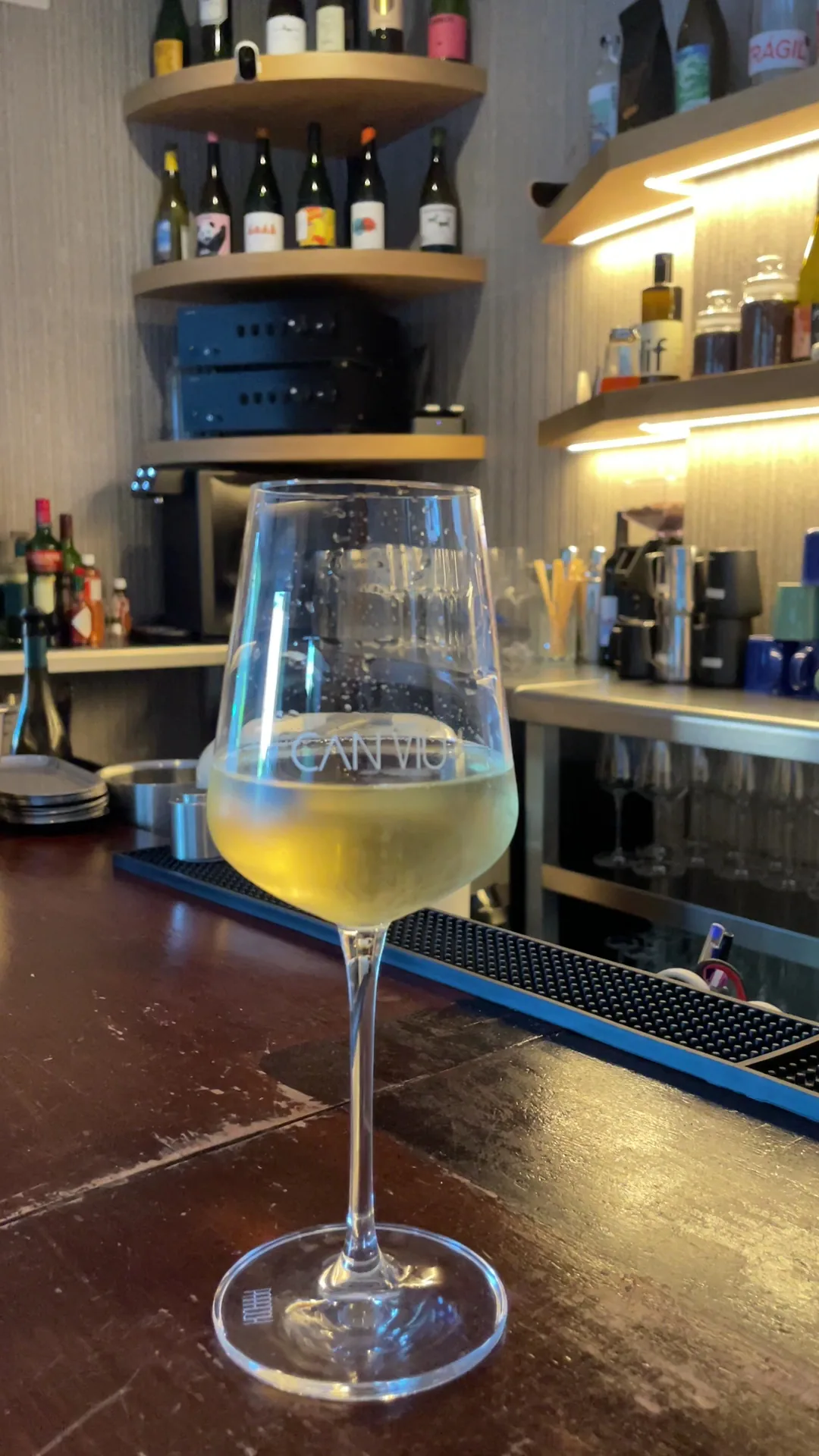 A glass of white wine on a bar counter