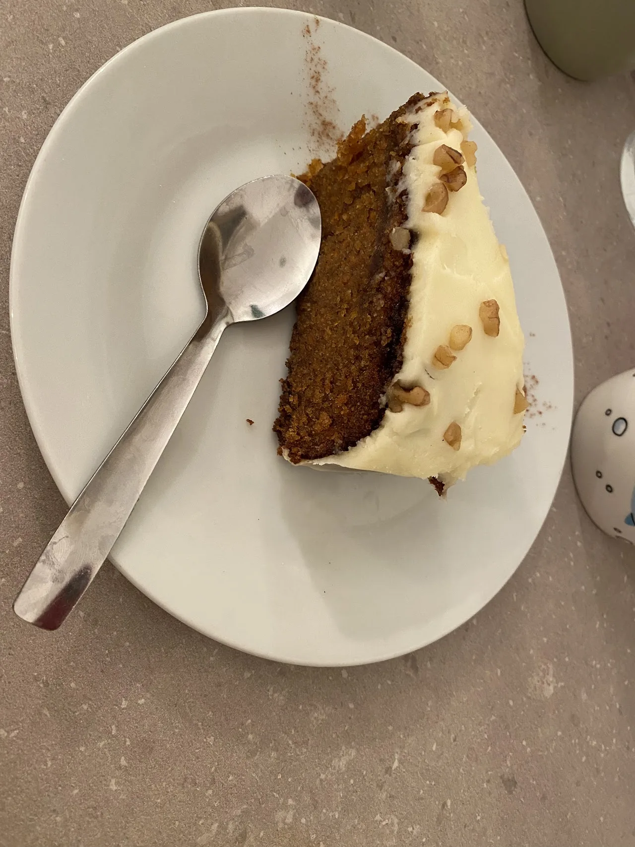 A slice of carrot cake with cream cheese frosting on a plate