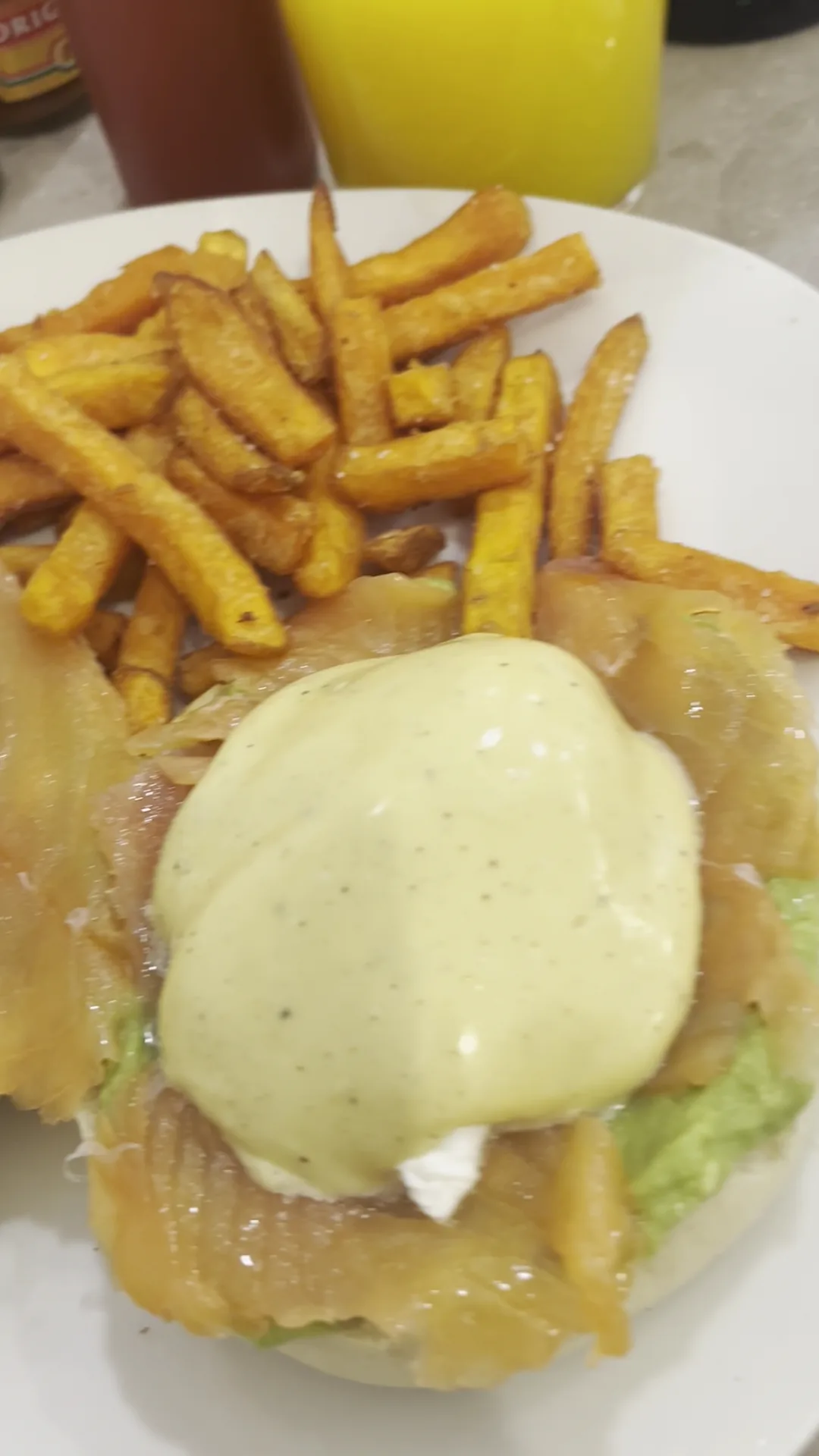 Eggs Benedict with hollandaise sauce beside a portion of sweet potato fries
