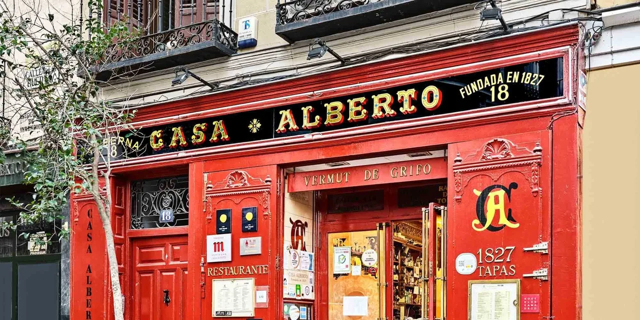A bright red shopfront with gold lettering reading Casa Alberto above the windows and doorway.