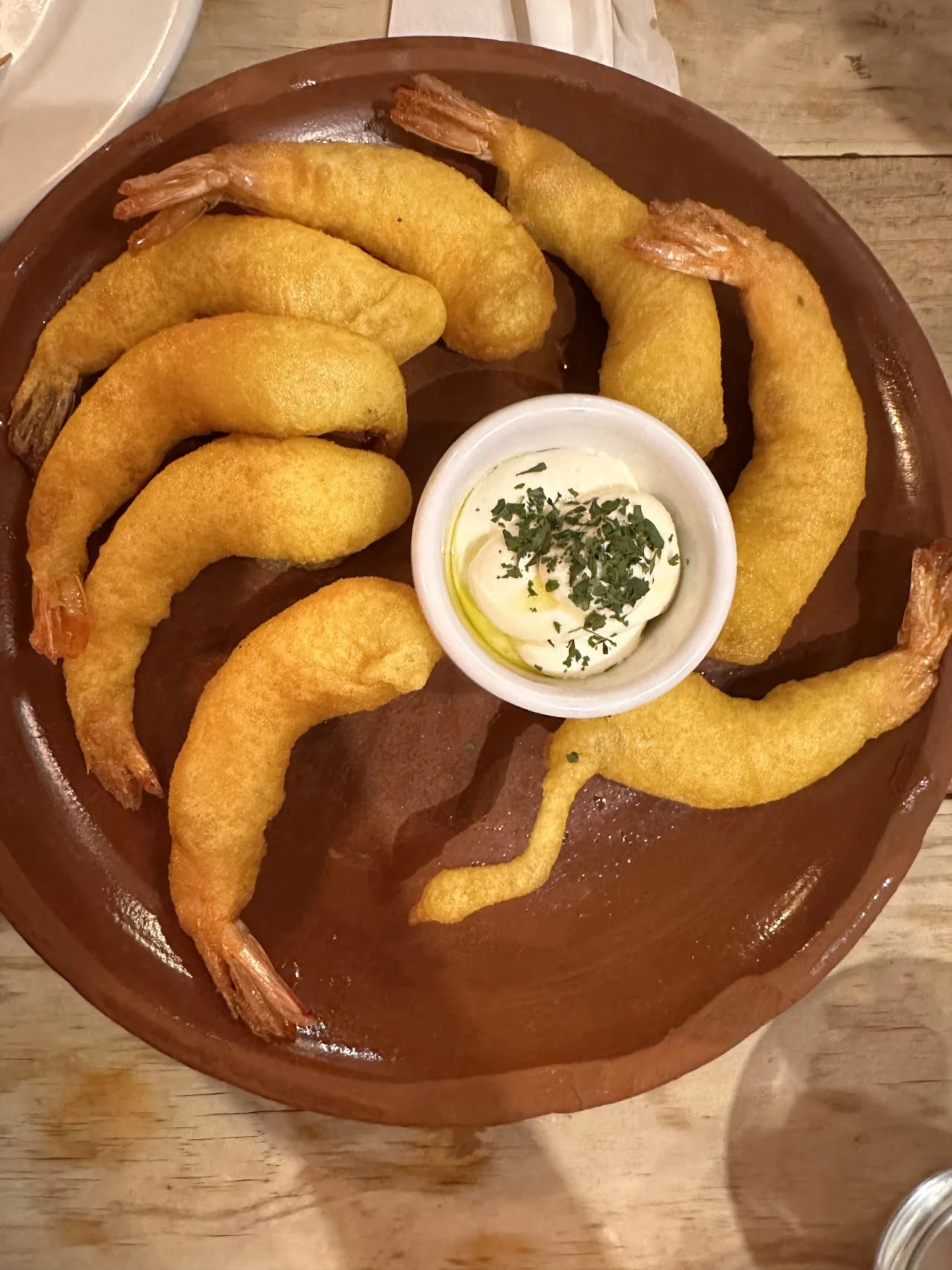 Battered and fried prawns arranged around a dipping sauce