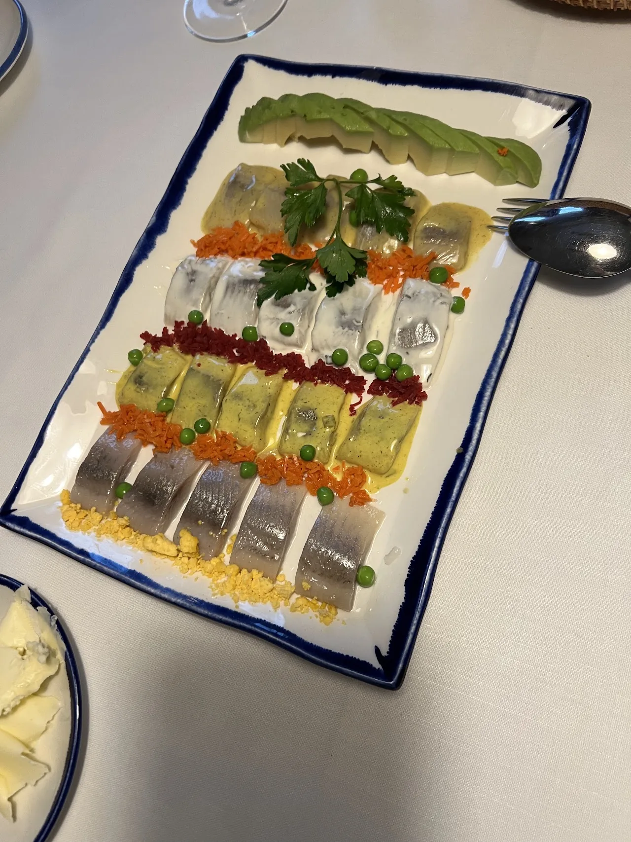 A row of open-faced canapés arranged on a long rectangular plate