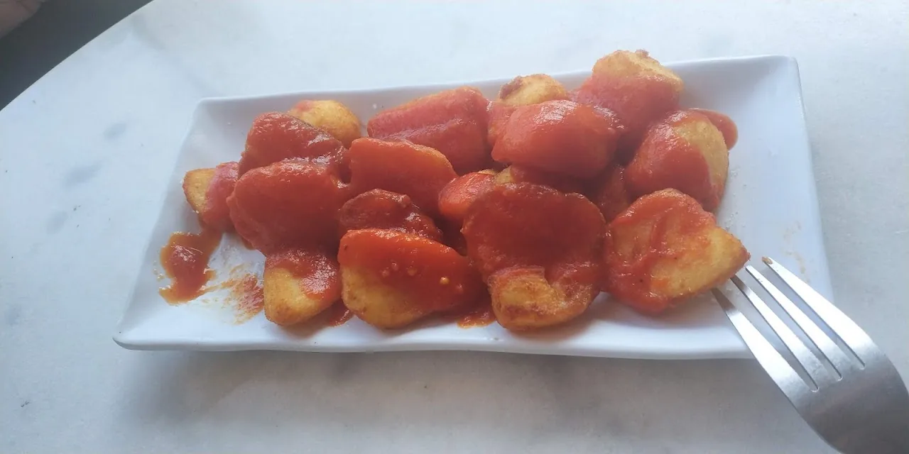 A plate of patatas bravas in spicy tomato sauce