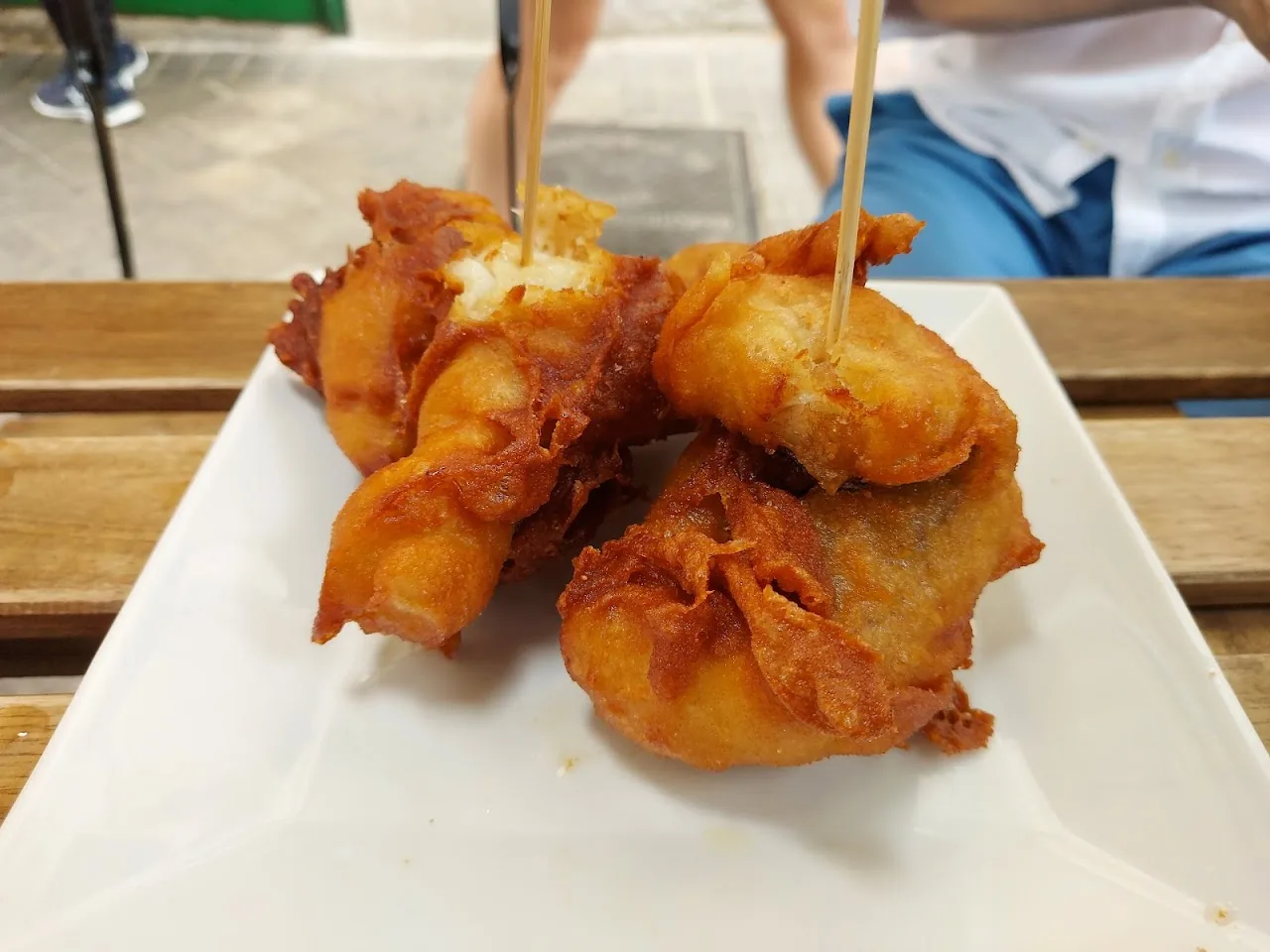 Fried battered pieces on skewers served on a plate