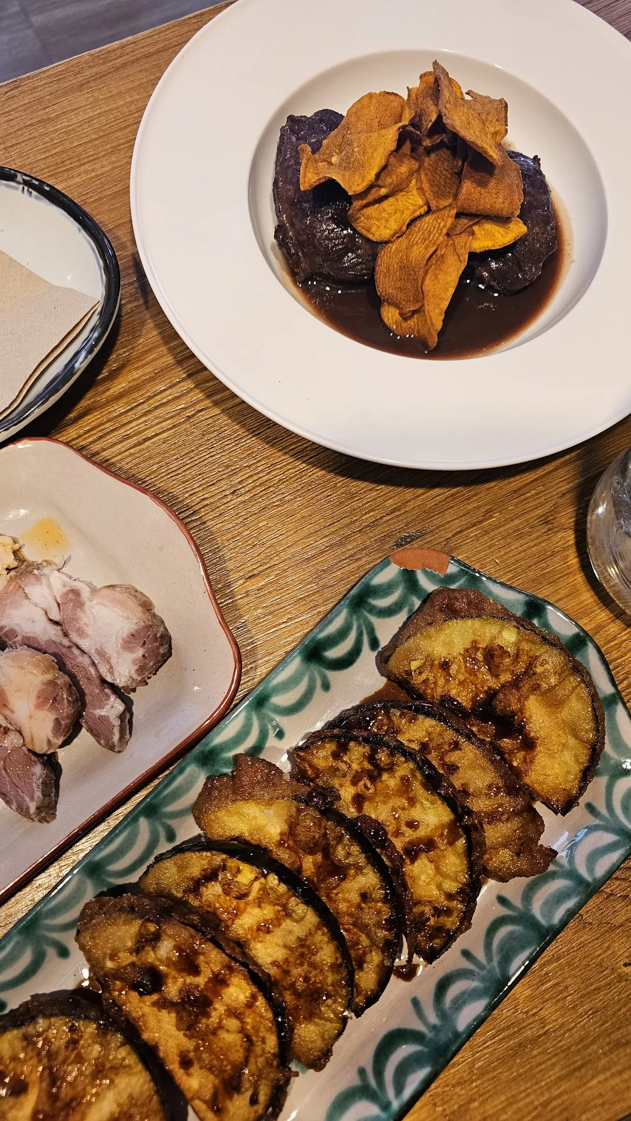 A table of tapas including octopus and grilled potato slices