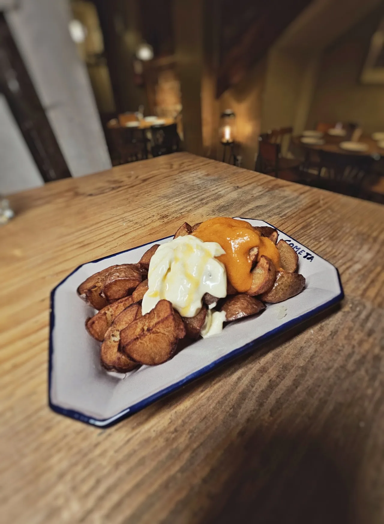 A plate of fried potatoes with a dip