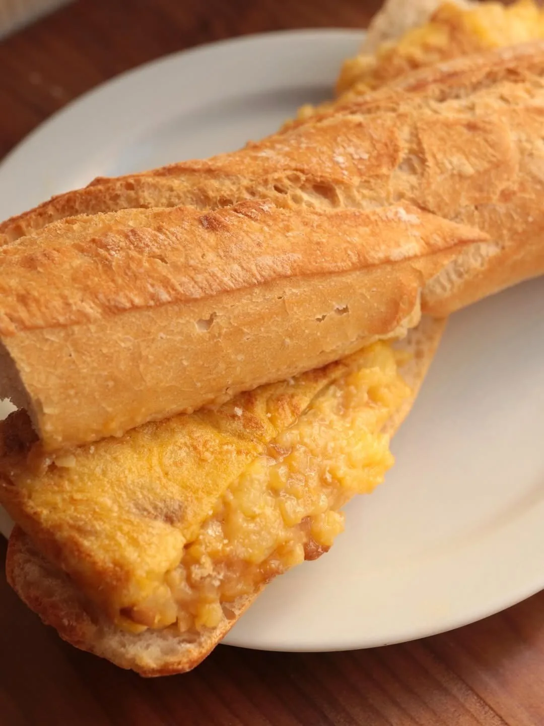 A tortilla sandwich in a baguette on a white plate