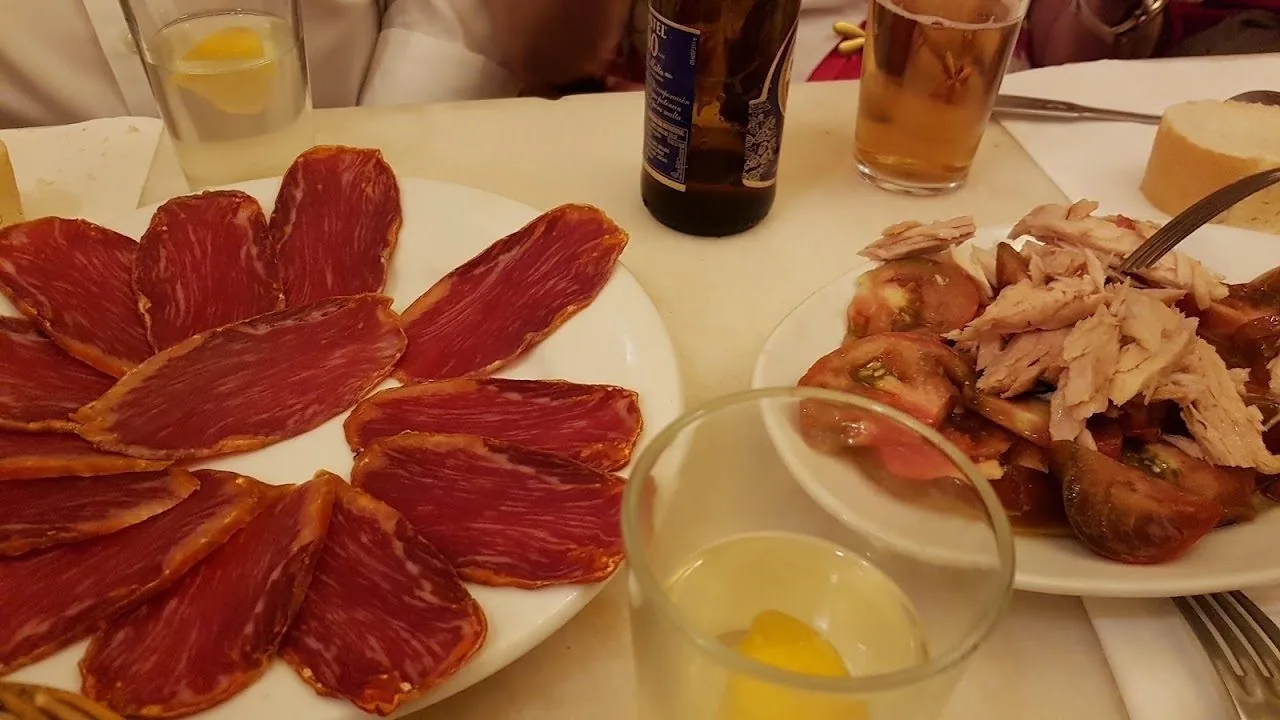 Plates of sliced cured ham and other cold cuts on a table