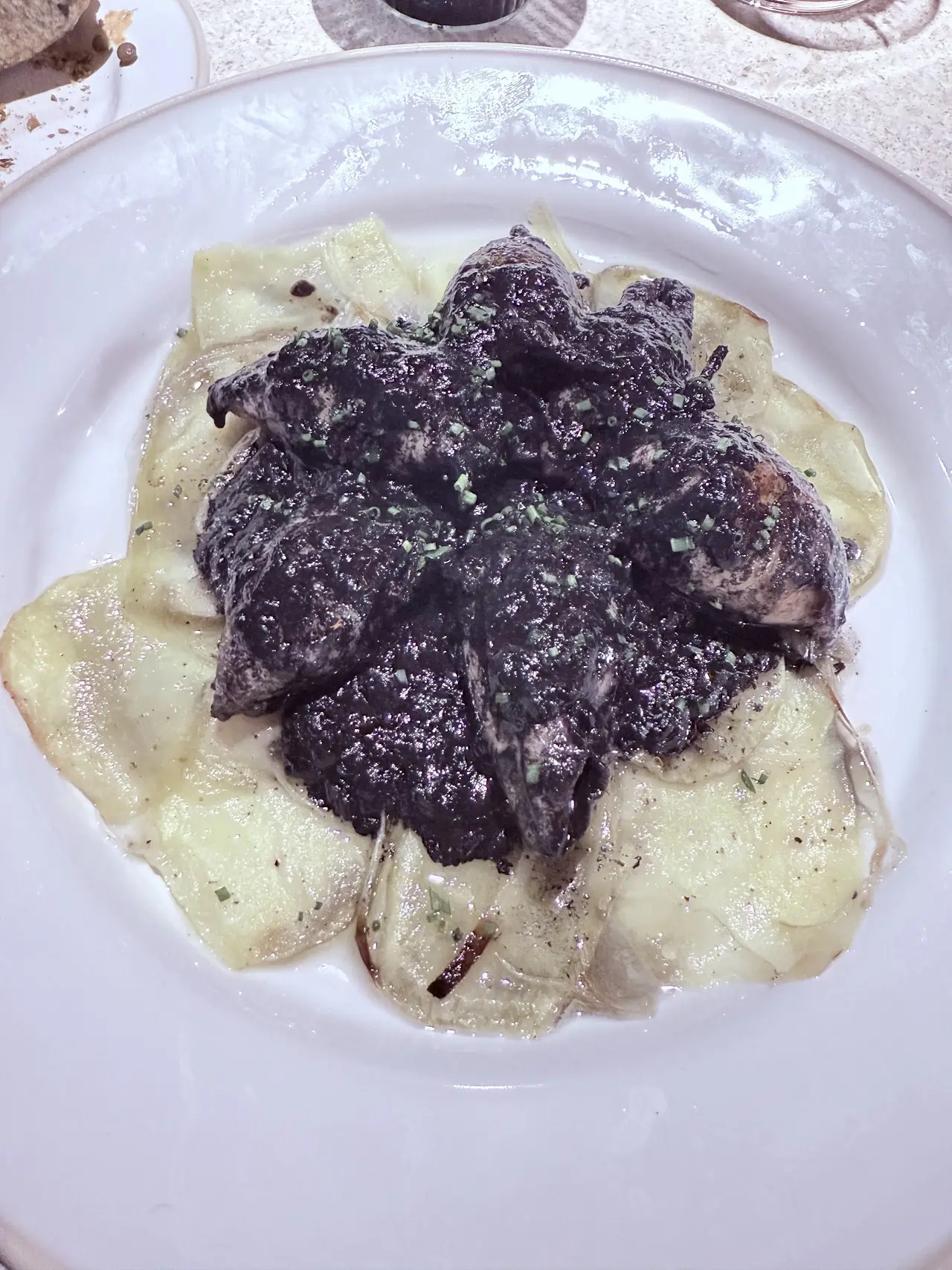 Handmade ravioli topped with sliced black truffle and grated cheese