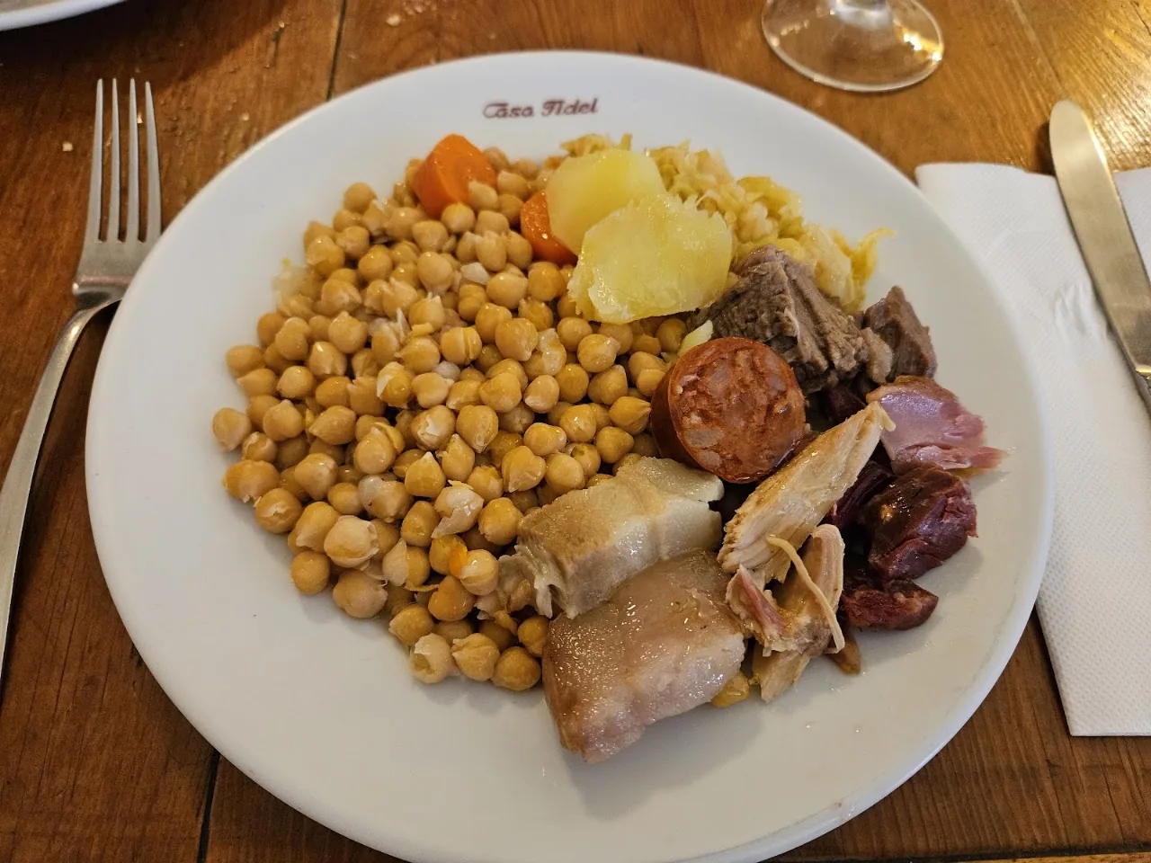 A plate of chickpeas, potato, and sausage from cocido