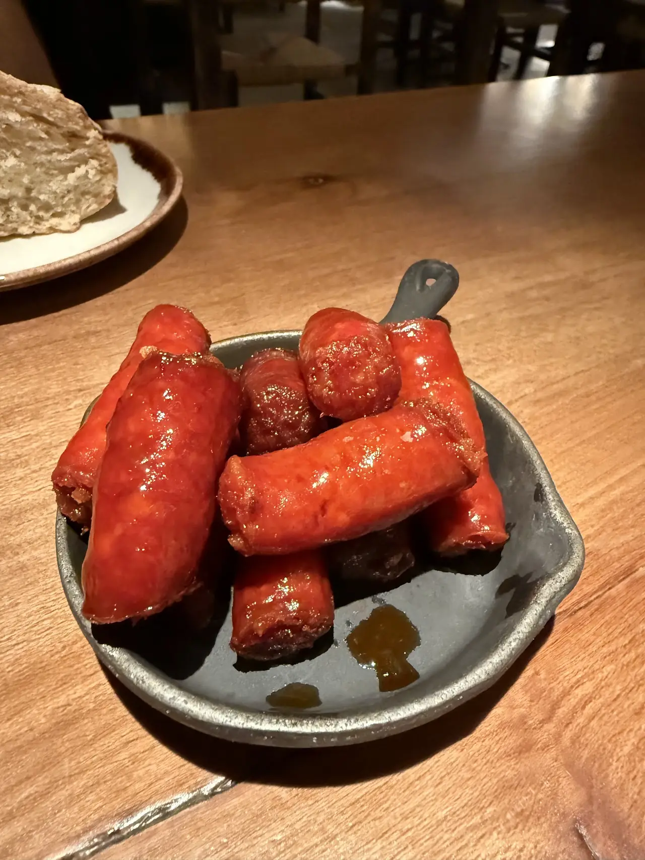 Small grilled chorizo sausages on a plate.
