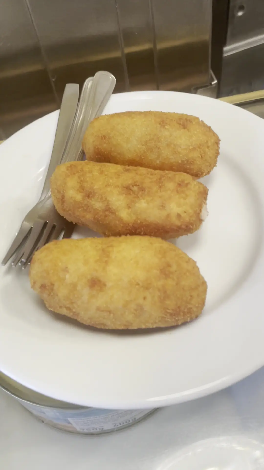 Three golden ham croquetas on a white plate at Casa Manolo