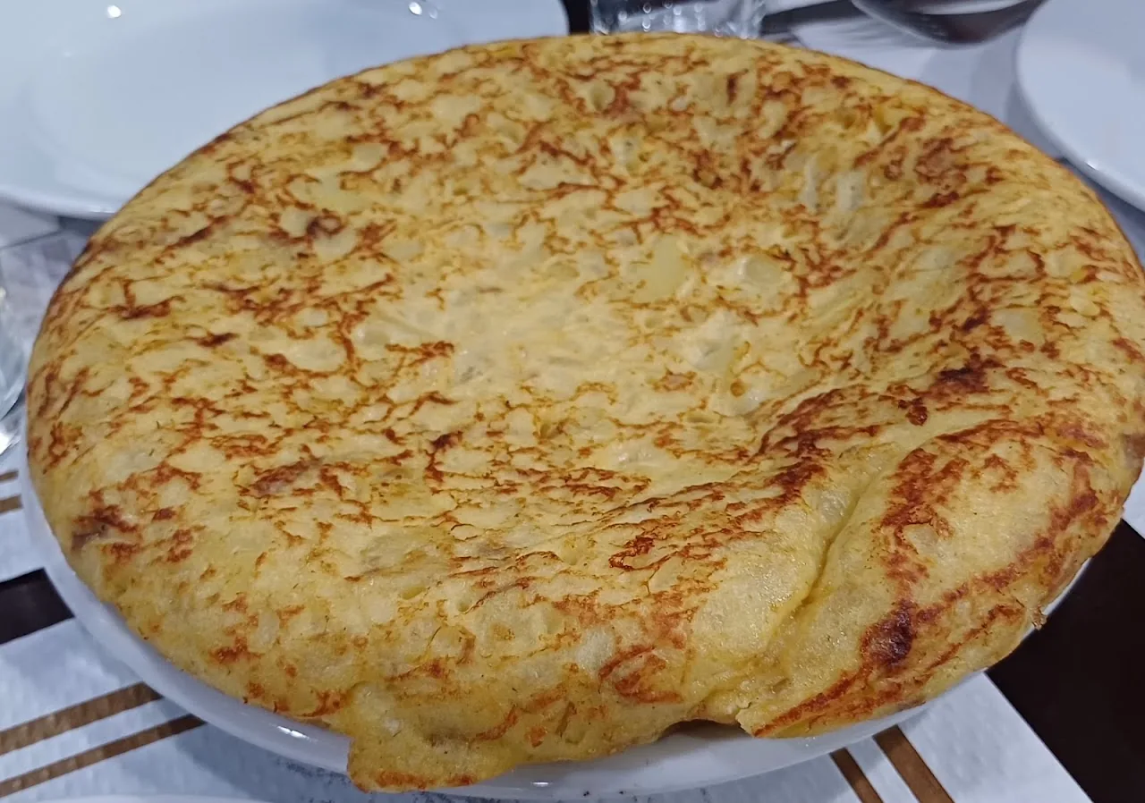 A whole Spanish potato omelette (tortilla espanola) on a plate