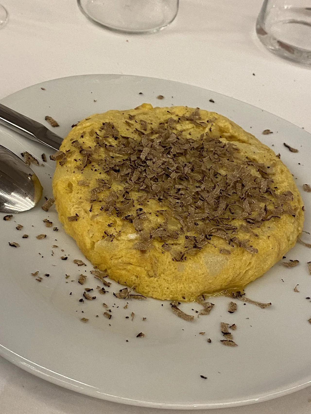 A round dish covered in shaved black truffle