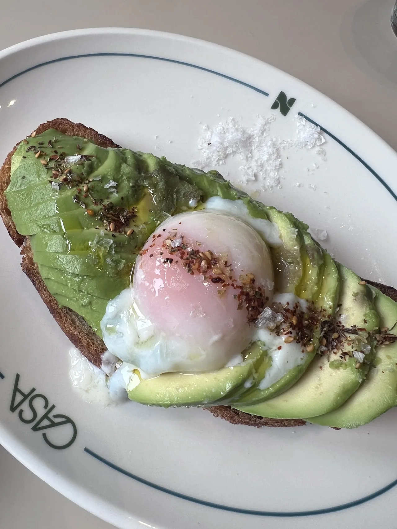 A slice of toast topped with sliced avocado and a poached egg
