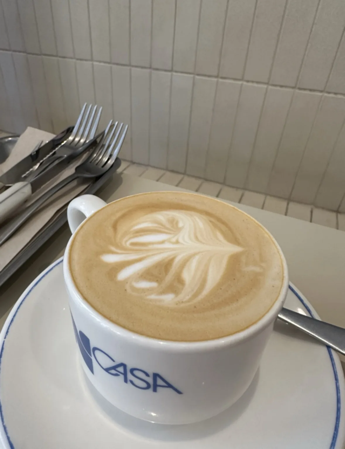 A cappuccino with latte art in a branded cup