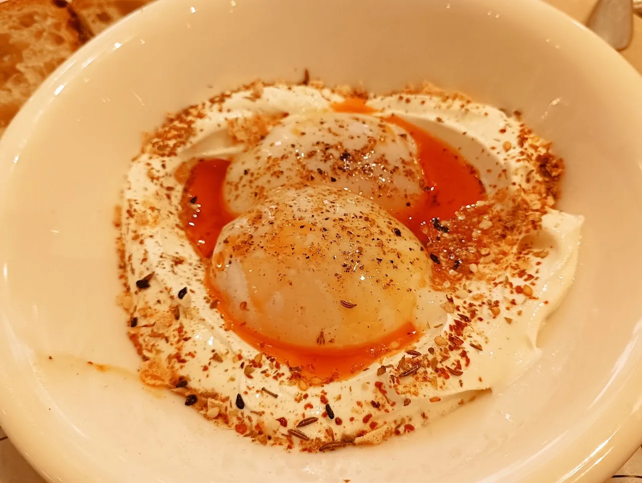 A poached egg over whipped hummus or yogurt, dusted with chili flakes