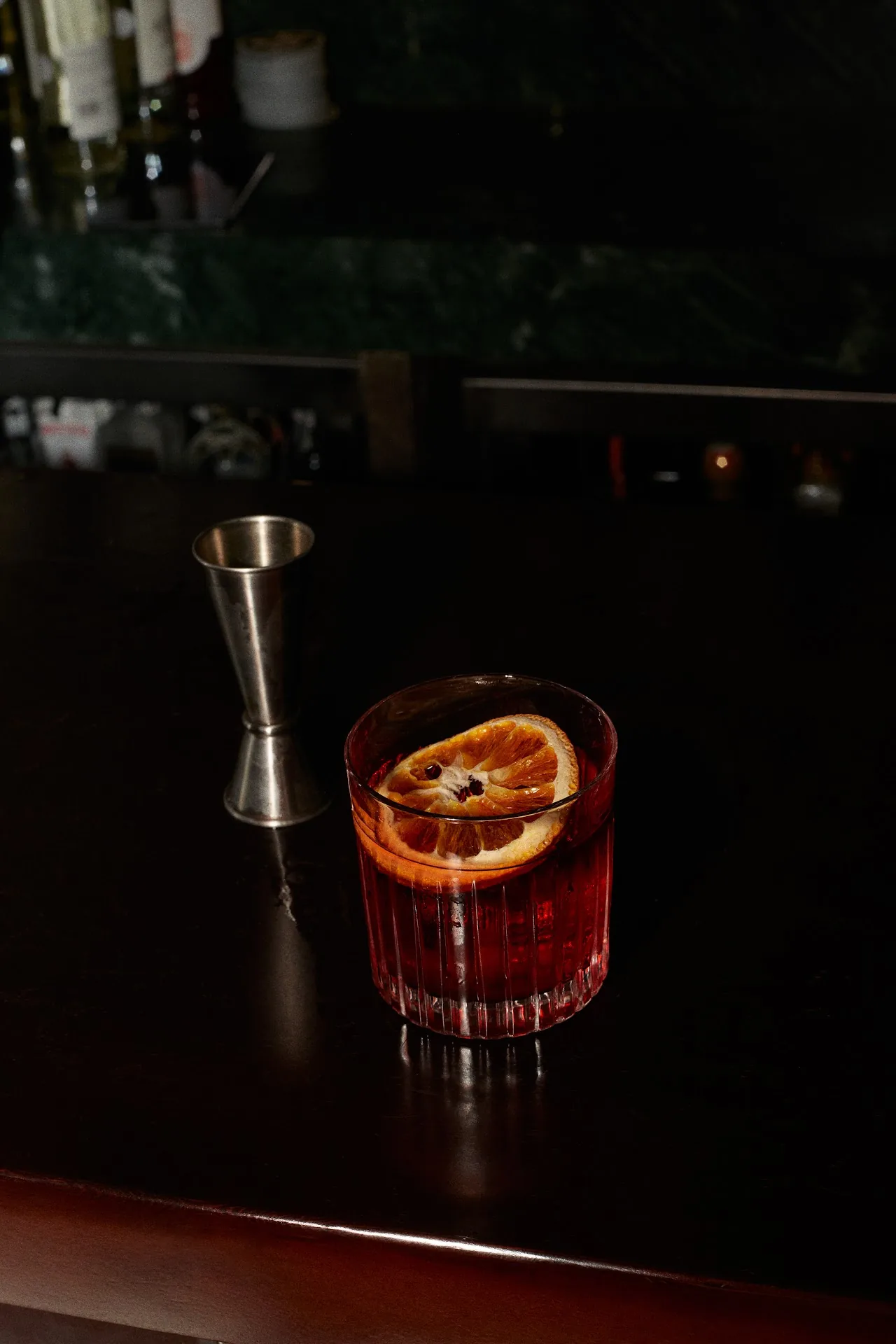 A cocktail with an orange twist in a rocks glass