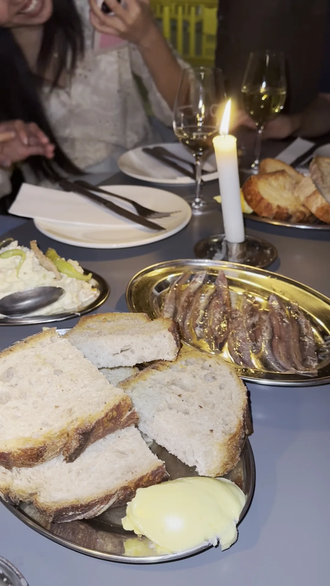 A plate of sliced bread and a wedge of cheese, dimly lit