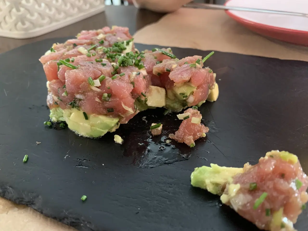 Tuna tartare over avocado on a slate board