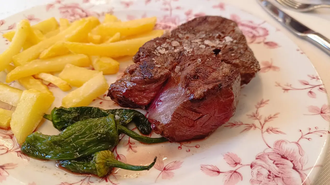 Grilled steak with sea salt, french fries and blistered green peppers on floral plate