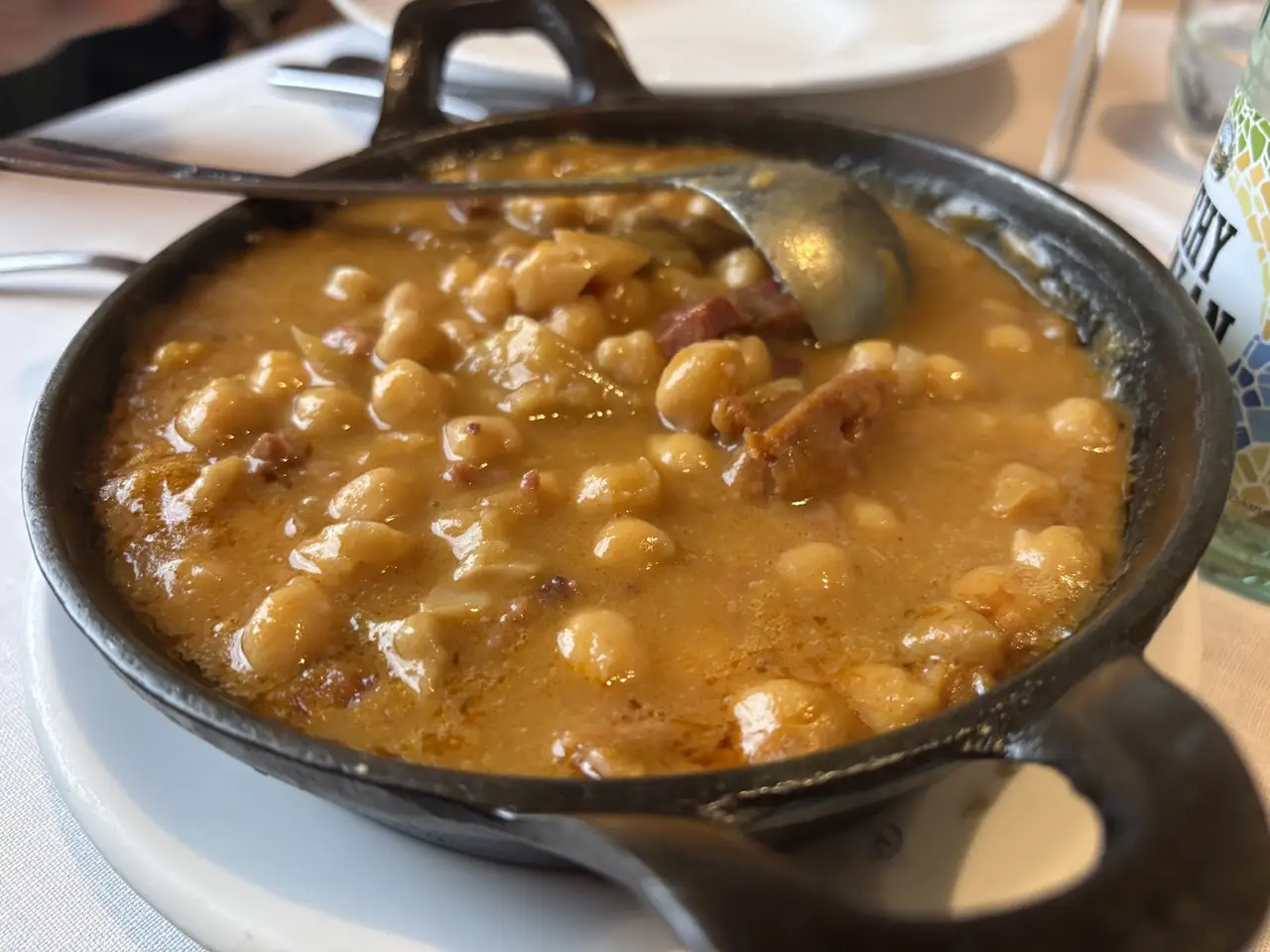 Chickpea stew with ham in a small cast iron serving pot