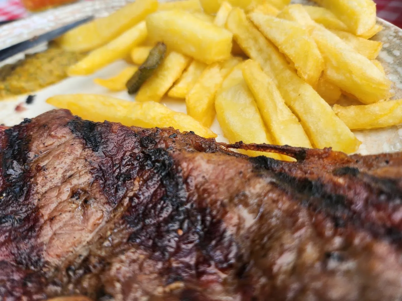 A grilled steak served with a pile of french fries